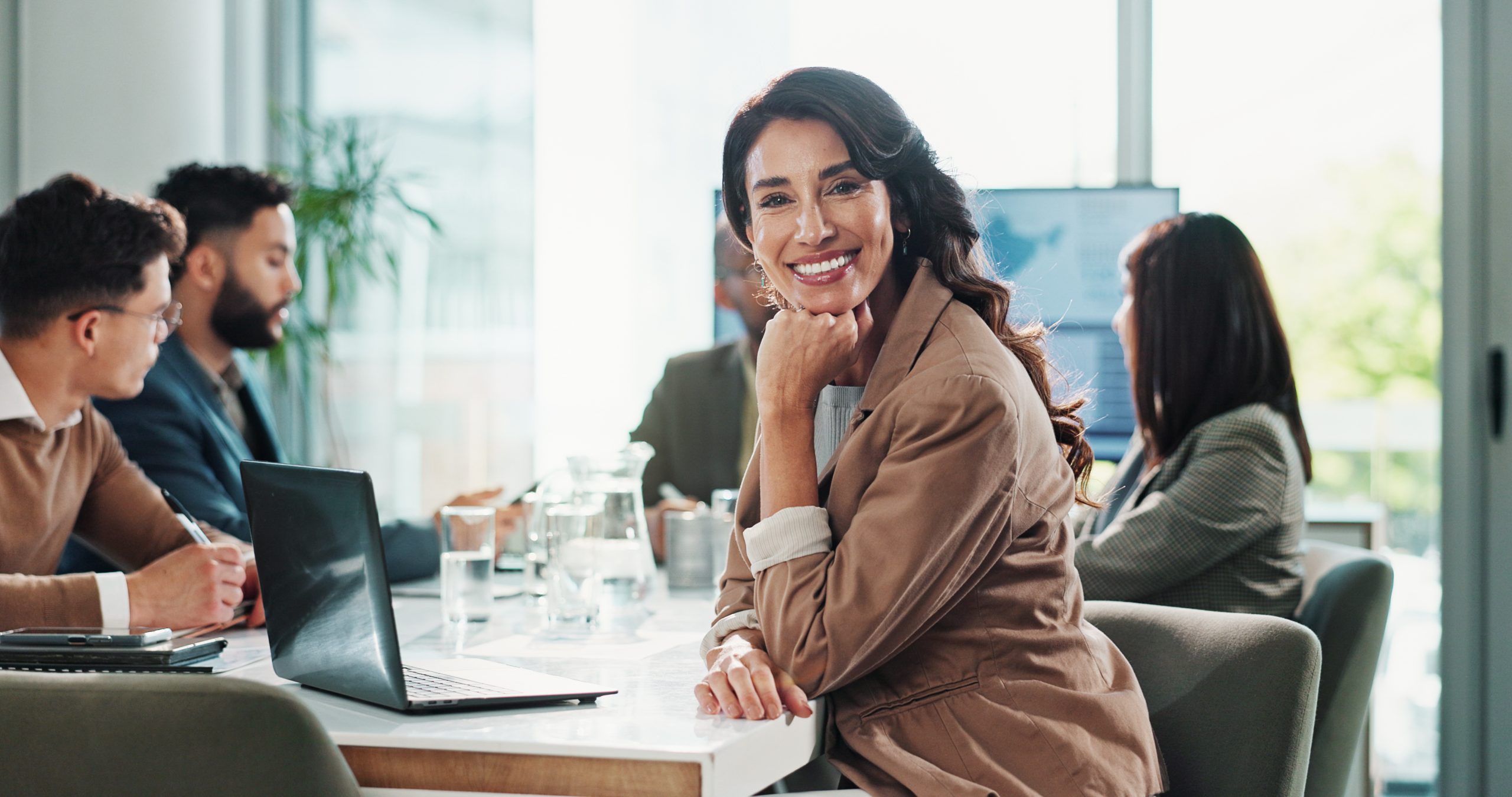 A smiling professional in a meeting with her team